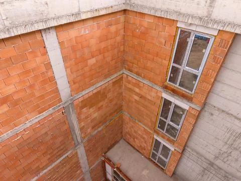 Building under construction shows brick walls and empty windows Foto stock