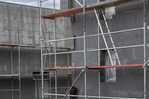 Building under construction shows a facade covered in dark gray insulation .. Fotos de archivo