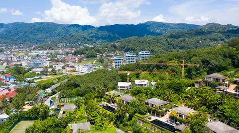 Building under construction surrounded by green mountains in sunny weather Stock Photos