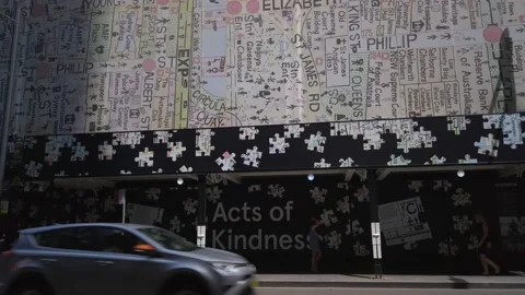 Building under constructions covered with Act of Kindness wall art and map Vídeos de archivo 133227900