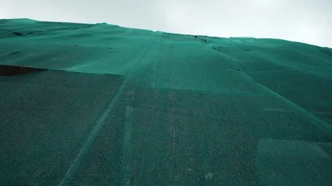 Building under reconstruction covered with green safety nets waving in the wind Stock Footage 80009906