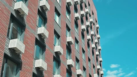 Building with a unique facade featuring brick walls and distinctive window Stock Footage 338446695