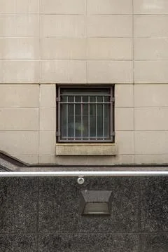 Building wall with barred window shows urban design and structure in a city.. Stock Photos