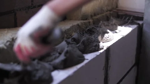 Building a wall. Builder applying mortar to white brick. Stock Footage 255649460