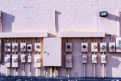 Building wall covered by rows of electric meters Stock Photos