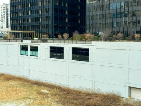 Building wall with empty windows near urban area with grass and modern stru.. Foto stock