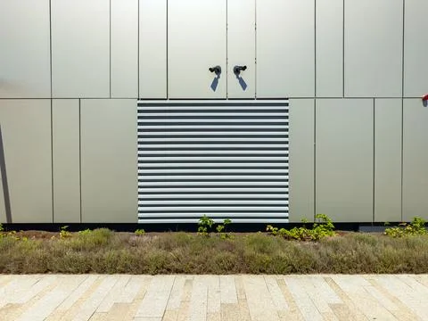 A building wall shows a mix of materials with a horizontal striped section an Stock Photos