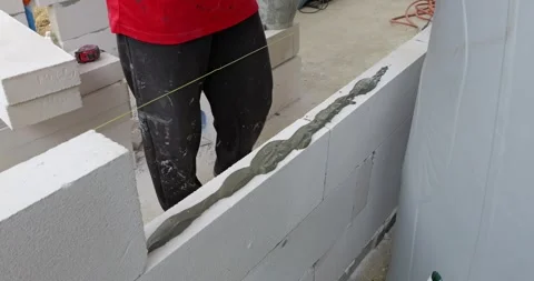 Building a wall using foam blocks construction site tutorial indoor close-up Stock Footage 330985765