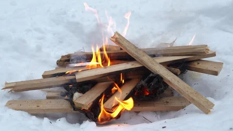 Building warm fire in cold snow for cozy warmth and comfort during winter nights Stock Footage 340550959