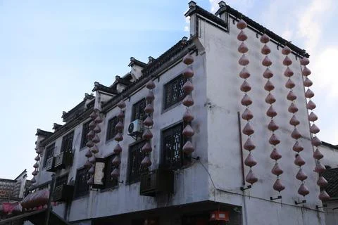 The building is white, with black tiles on the eaves and windows hanging re.. Stock Photos