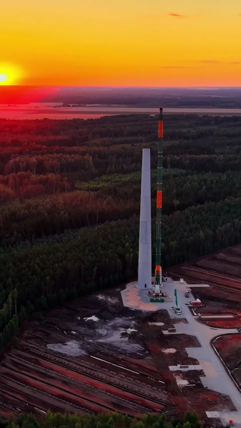 Building a wind turbine tower during a colorful sunset using a large mobile Stock Footage 339646818