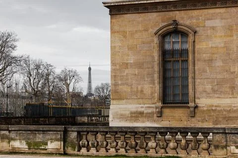 A building with a window and a statue of the Eiffel Tower in the background 스톡 사진