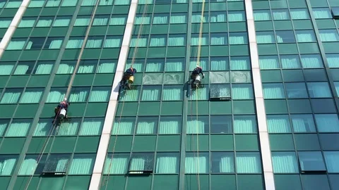 Building Window Cleaners Hanging on Ropes Cleaning Windows on Office Building Stock Footage 111783345