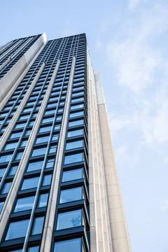 Building with windows, view from below, clouds in the sky Stock Photos