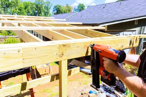 Building wooden structure using nail gun in backyard Stock Photos