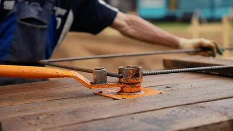 Building worker bending rebar using manual tool for construction Stock Photos