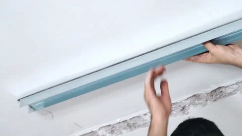 Building workers installing metal profile to the ceiling for drywall assembling Stock Footage 133800755