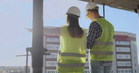 Building workers working at construction site, builders looking in blueprint Stock-Footage 112810511