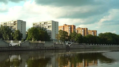 Buildings along a river with trees and a cloudy sky in an urban area Vidéo 340448046