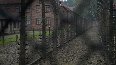 Buildings of Auschwitz concentration camp camera moves behind barbed wire fence Video stock 68402412