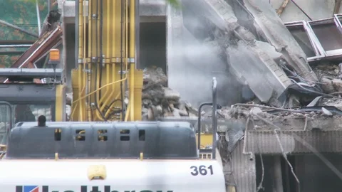 Buildings being destroyed by two diggers in London Stock Footage 97999771