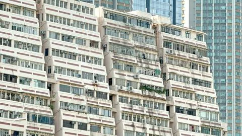 The building's facade features a distinctive pattern of windows and balconies Stock Photos