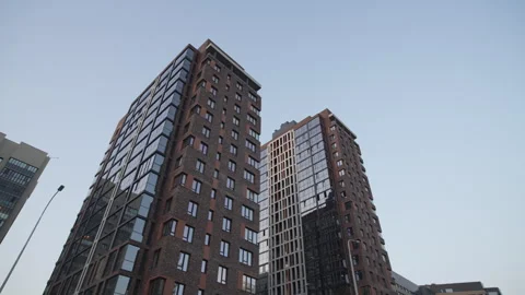 Buildings feature angular forms with brown and glass facades Vídeos de archivo 326480139