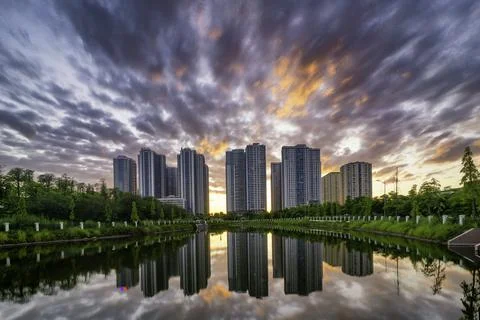 Buildings with reflections on lake at sunset at Gold mark city park. Hanoi ci Stock Photos