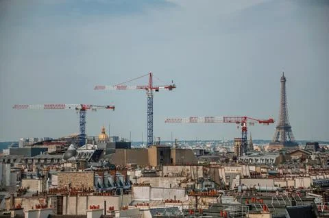 Buildings rooftops with cranes and Eiffel Tower in Paris Stock Photos