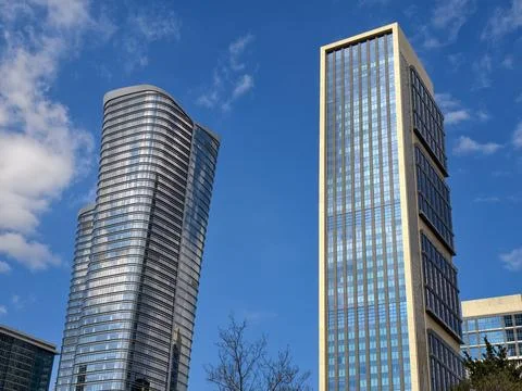 Buildings shine under blue sky in modern city with clouds Stock Photos