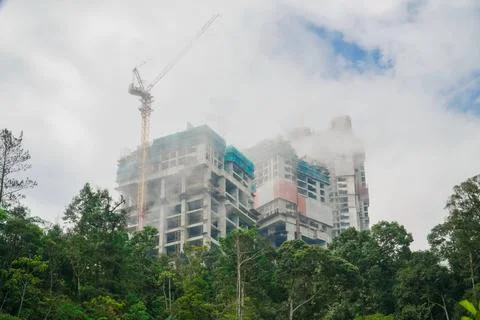 Buildings under construction and clouds above them with trees. a building b.. Stock Photos