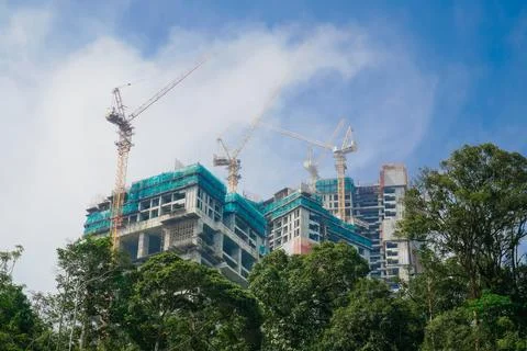Buildings under construction and clouds above them with trees. a building b.. Stock Photos