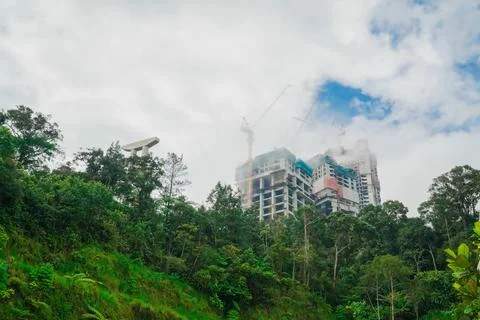 Buildings under construction and clouds above them with trees. a building b.. Stock Photos