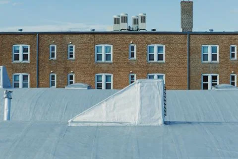 Buildings with windows and rooftop structure in a city during clear weather Stock Photos