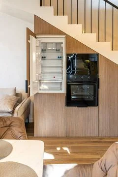Built-in empty refrigerator and oven under modern staircase 库存照片