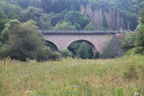 Built a stone arch bridge over a green valley Stock Photos
