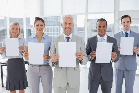 Buisness team holding up blank pages Stock Photos