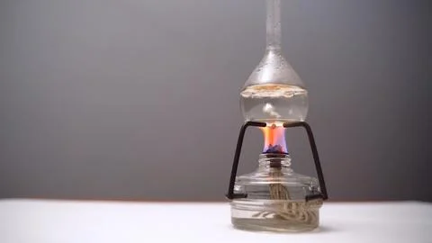 Bulb with boiling liquid on burner flame. Flask heated on burner in laboratory Stock Photos