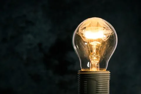 The bulb on dark background with flame inside Stock Photos