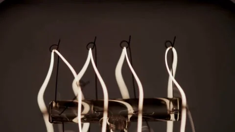 Bulb filaments glow bright before camera pans up slowly Stock Footage 329657322