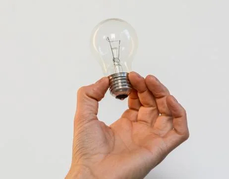 Bulb in a hand Stock Photos