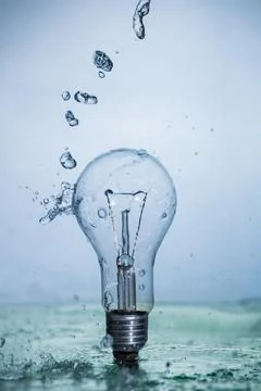 Bulb lamp with motion freezed water splashes. Stock Photos