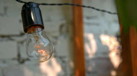 The bulb lights up in front of a white wall Stock Footage 65421362