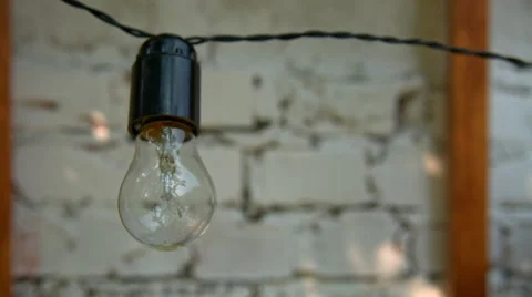 The bulb lights up in front of a white wall Stock Footage 65421482
