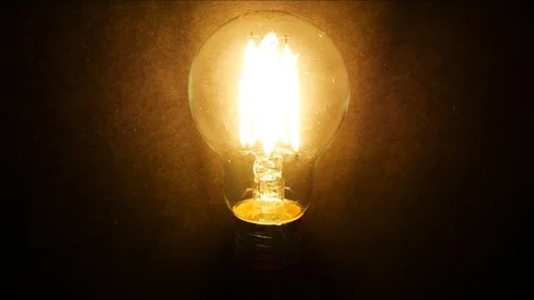 The bulb stands on black background and lights up. Stock-Footage 104876123