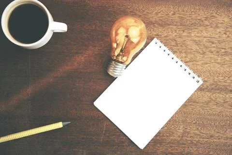 Bulb,notepad and coffee Stock Photos