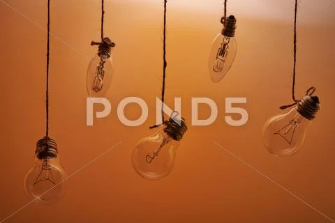 Bulbs hanging on an orange background Stock Photos