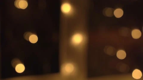 Bulbs or garlands hang on the window and glow on a blurry background, creating a Stock Footage 201040004