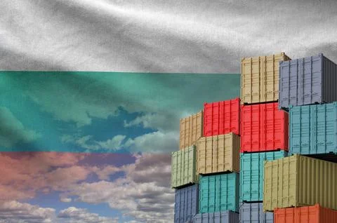 Bulgaria flag and big stack of shipping cargo containers in docks with sky Foto stock