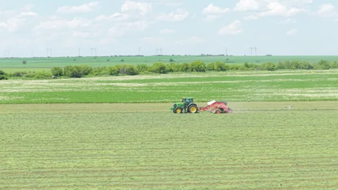 Bulgarian Tractor green field Working in Spring Wheat Field Under Blue Sky Stock Footage 310367607